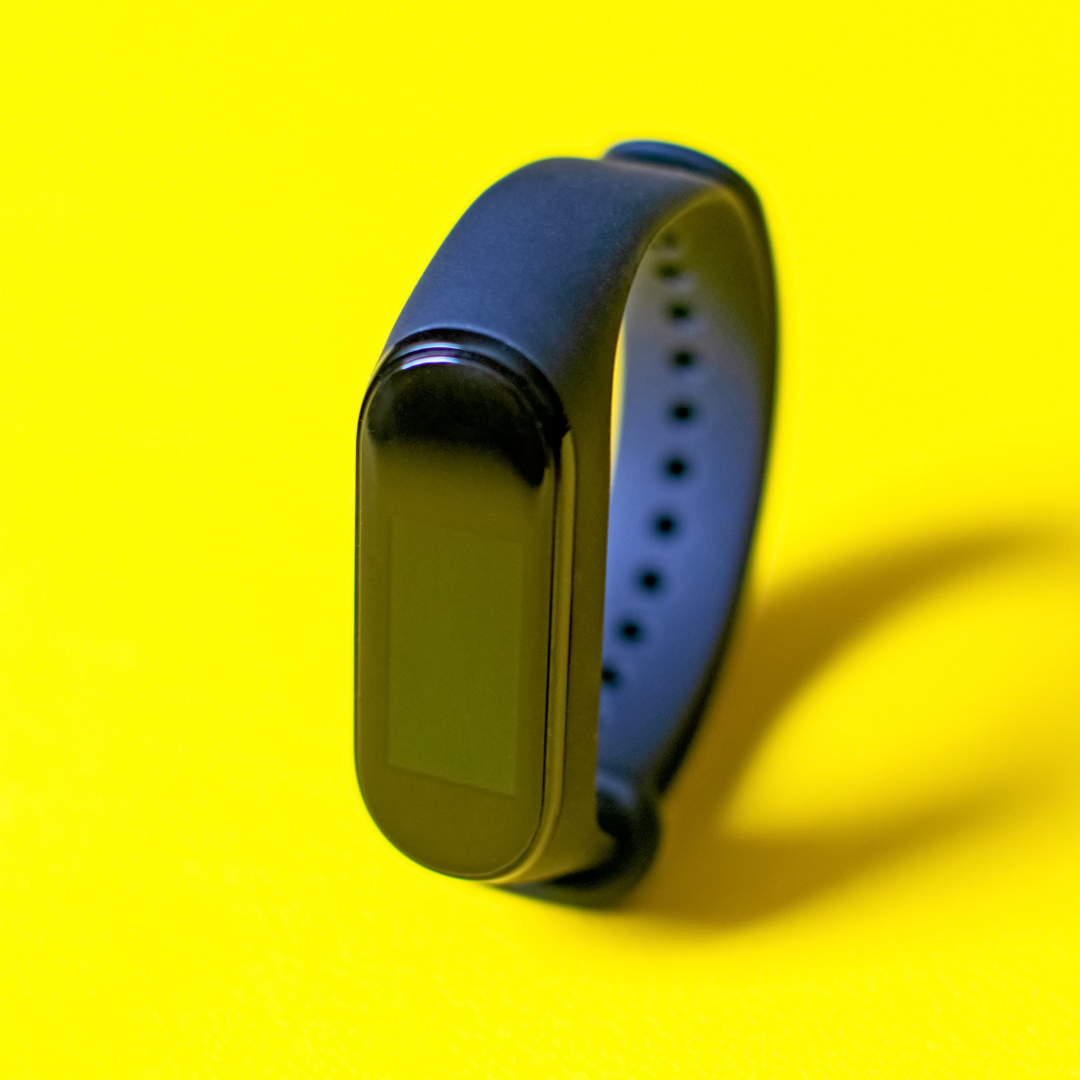 blue fitbit watch on yellow background